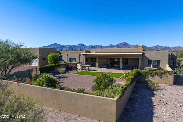 back of house with a mountain view and a patio area