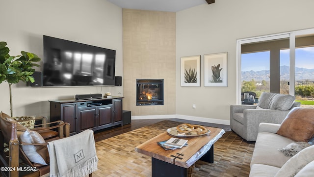 2321 Circulo De Anza, Tubac, AZ 85646 - living area featuring high vaulted ceiling, a mountain view, baseboards, a fireplace, and wood finished floors