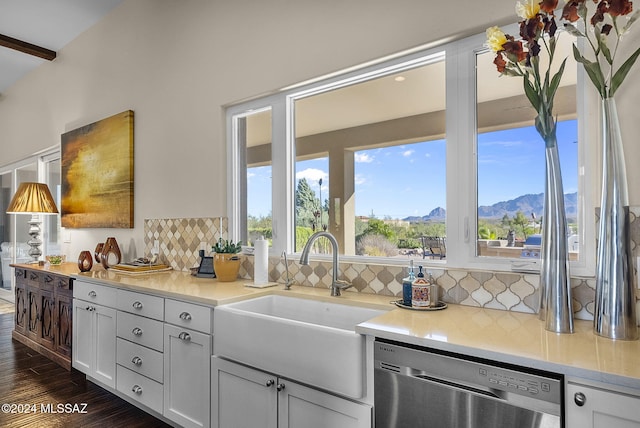 kitchen featuring dark hardwood / wood-style flooring, white cabinetry, stainless steel dishwasher, a mountain view, and decorative backsplash