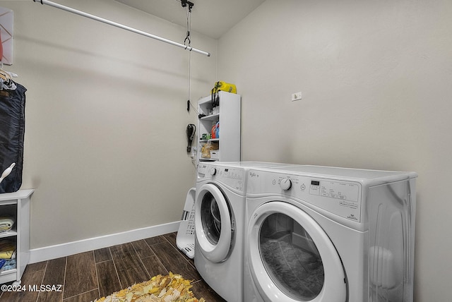 laundry area featuring washing machine and clothes dryer and dark hardwood / wood-style flooring