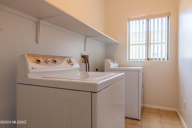 laundry room with independent washer and dryer and light tile patterned floors