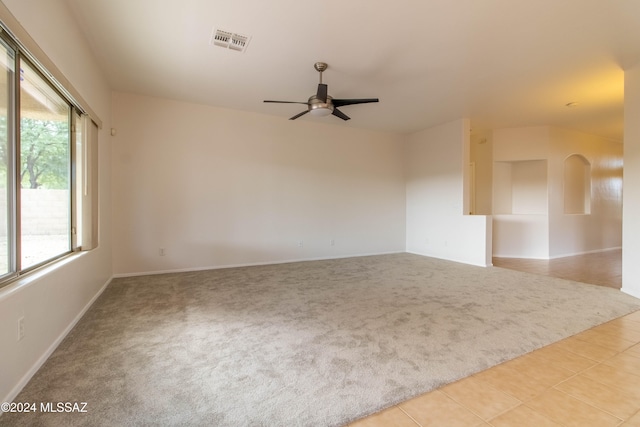 carpeted spare room with a healthy amount of sunlight and ceiling fan