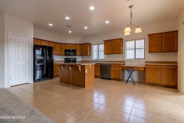 kitchen featuring light tile patterned floors, a kitchen breakfast bar, black appliances, decorative light fixtures, and a center island