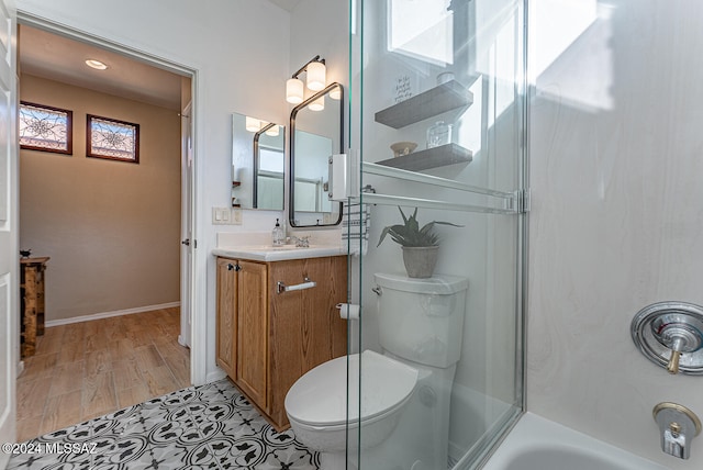 full bathroom with toilet, wood-type flooring, a wealth of natural light, vanity, and bathing tub / shower combination