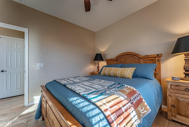 bedroom with light hardwood / wood-style flooring, lofted ceiling, and ceiling fan