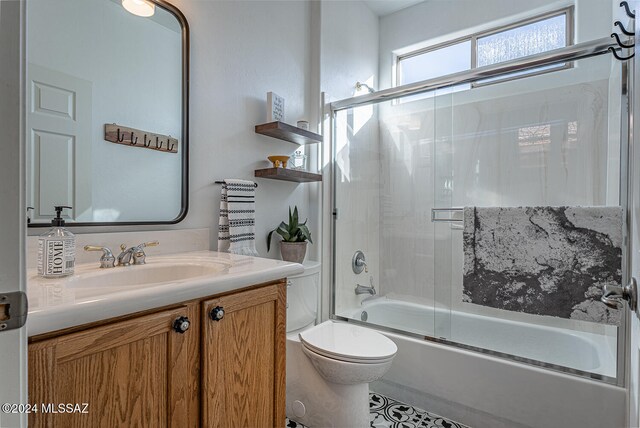 full bathroom with vanity, toilet, and bath / shower combo with glass door