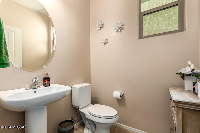 bathroom featuring toilet, sink, and tile patterned floors