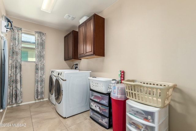 laundry room with cabinets, independent washer and dryer, and light tile patterned floors