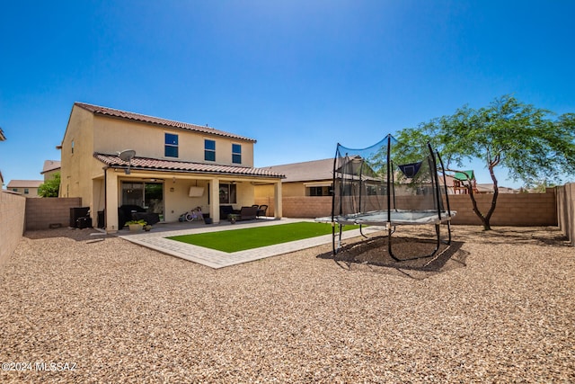 rear view of house with a patio and a trampoline