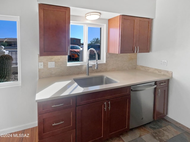 kitchen featuring a sink, decorative backsplash, dishwasher, and light countertops