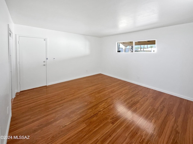 unfurnished room with baseboards and wood finished floors