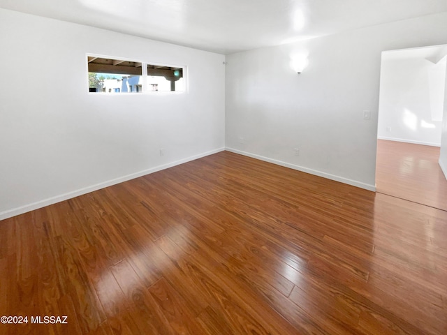 empty room with baseboards and wood finished floors