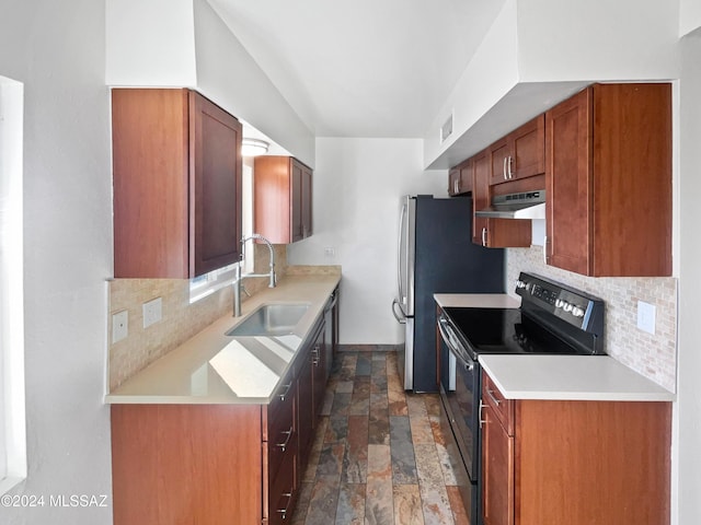 kitchen featuring stone finish floor, under cabinet range hood, a sink, backsplash, and black / electric stove