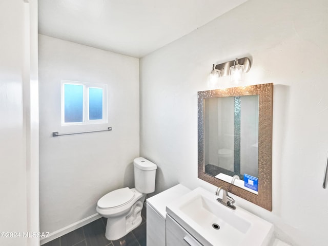 bathroom with vanity, baseboards, and toilet