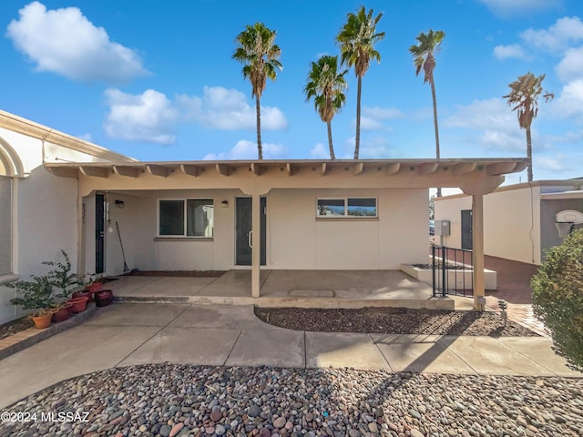 back of property with a patio area and stucco siding