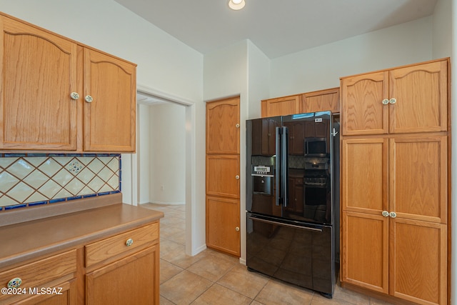 kitchen with black fridge with ice dispenser, tasteful backsplash, and light tile patterned flooring