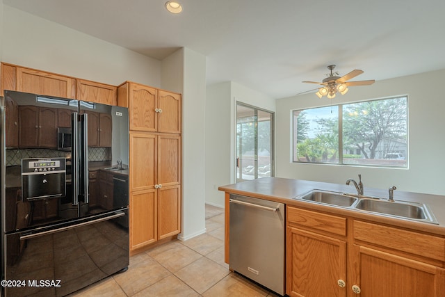 kitchen featuring backsplash, black fridge, sink, and a healthy amount of sunlight