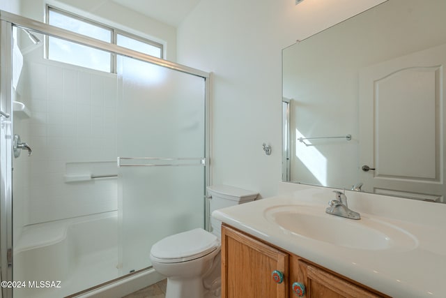 bathroom featuring vanity, toilet, and walk in shower