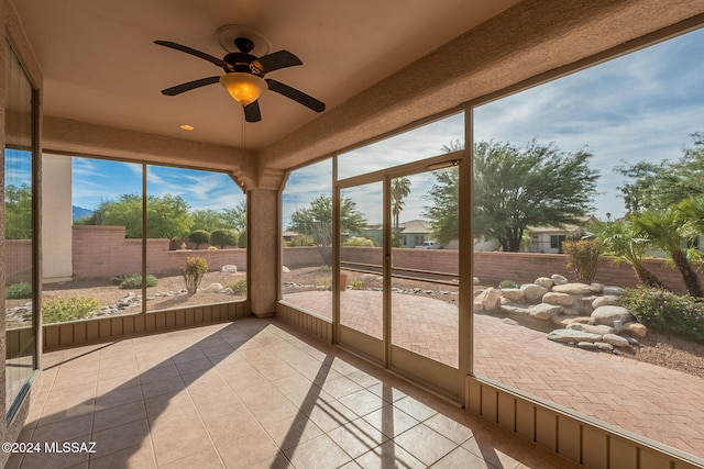 unfurnished sunroom featuring ceiling fan