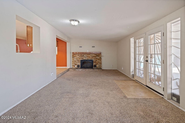 unfurnished living room featuring french doors and light colored carpet