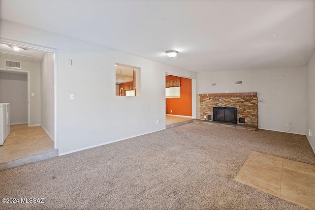 unfurnished living room featuring washer / dryer and carpet