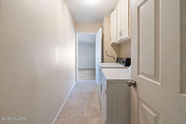 washroom featuring independent washer and dryer, light tile patterned floors, and cabinets