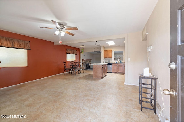 kitchen with ceiling fan, dishwasher, a skylight, pendant lighting, and a center island