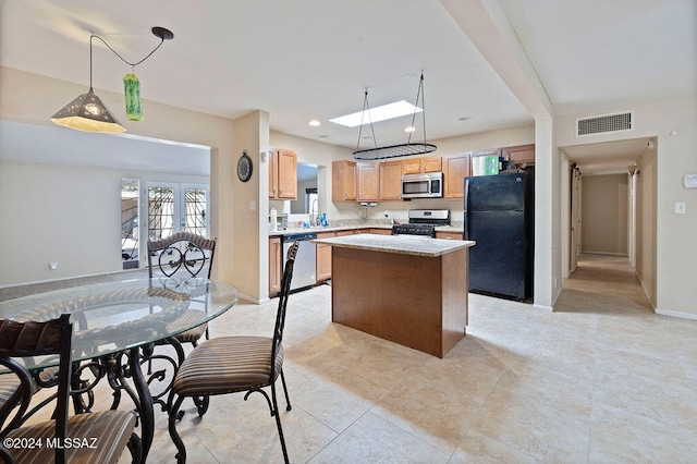 kitchen featuring appliances with stainless steel finishes, sink, a center island, pendant lighting, and light tile patterned floors