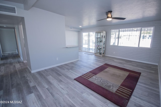 unfurnished living room with ceiling fan and wood-type flooring