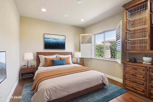 bedroom with recessed lighting, dark wood finished floors, and baseboards