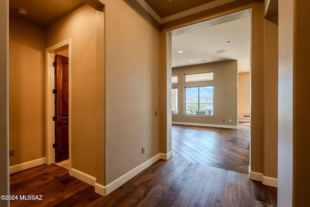 corridor featuring baseboards and dark wood finished floors