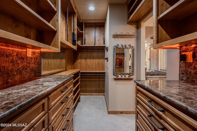 walk in closet featuring light carpet