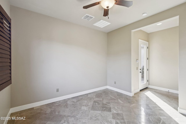 empty room featuring a ceiling fan, visible vents, and baseboards