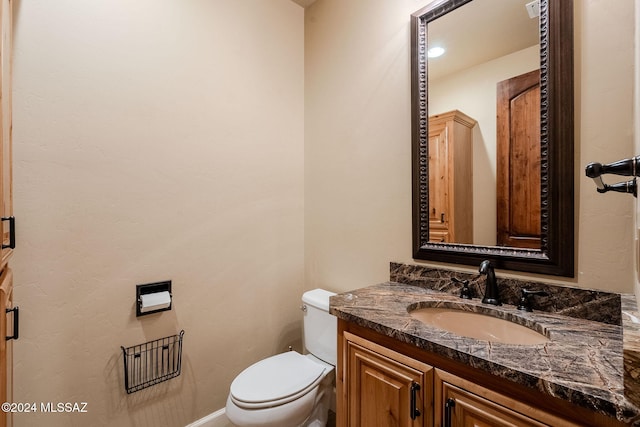 half bathroom with toilet and vanity