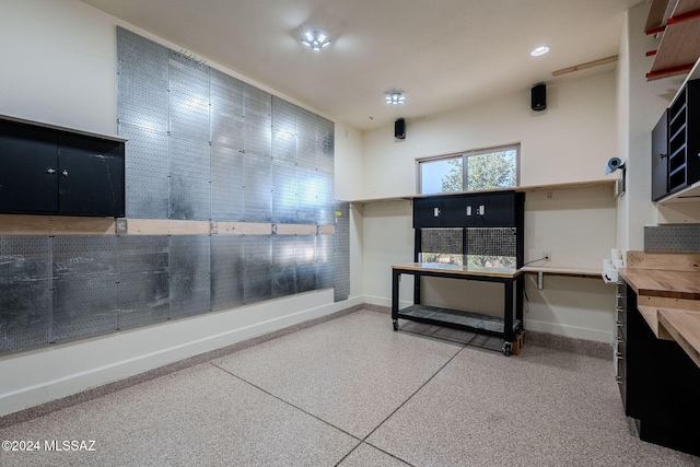 miscellaneous room with recessed lighting, baseboards, and speckled floor