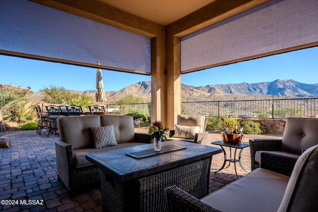 view of patio featuring a fenced backyard, a mountain view, an outdoor hangout area, and outdoor dining space