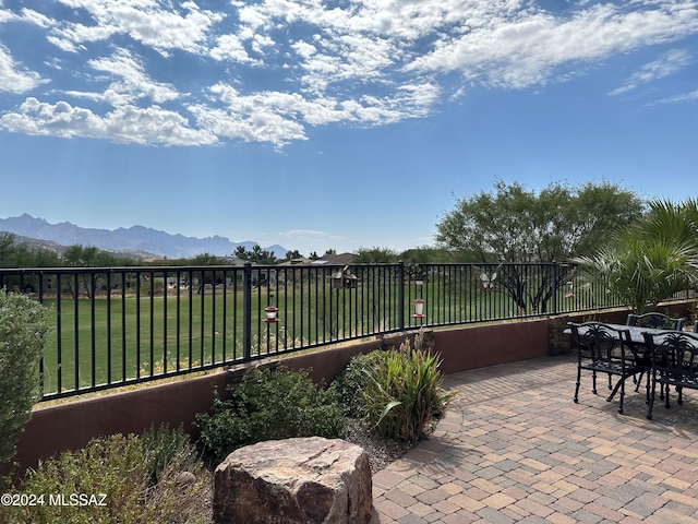 view of patio / terrace with fence and a mountain view