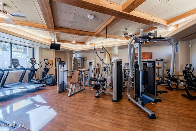 workout area with a drop ceiling and wood finished floors