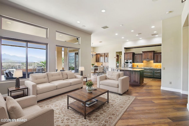 living area with baseboards, visible vents, wood finished floors, a mountain view, and recessed lighting