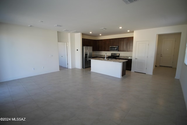 kitchen featuring dark brown cabinets, stainless steel appliances, a center island with sink, and sink