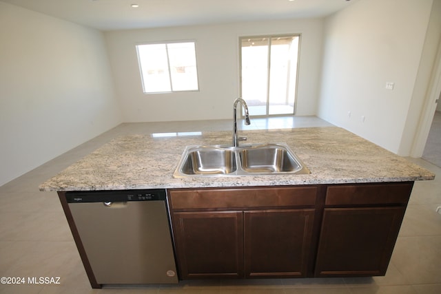 kitchen with dark brown cabinetry, sink, light stone counters, light tile patterned floors, and dishwasher