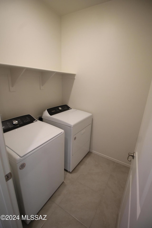 laundry area with washing machine and dryer and light tile patterned flooring