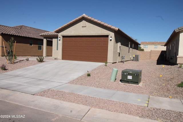 view of front of home with a garage and cooling unit