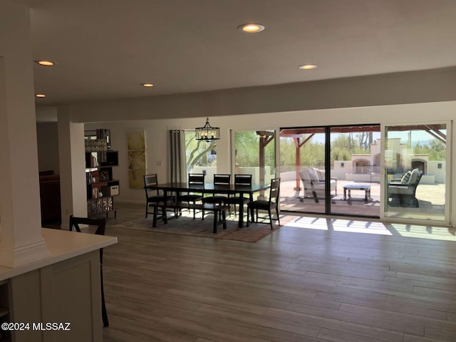 dining space with hardwood / wood-style flooring and a chandelier