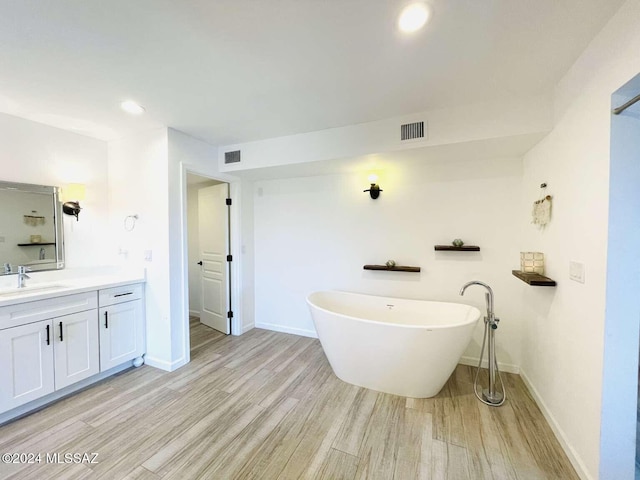 bathroom featuring vanity, hardwood / wood-style floors, and a bathtub