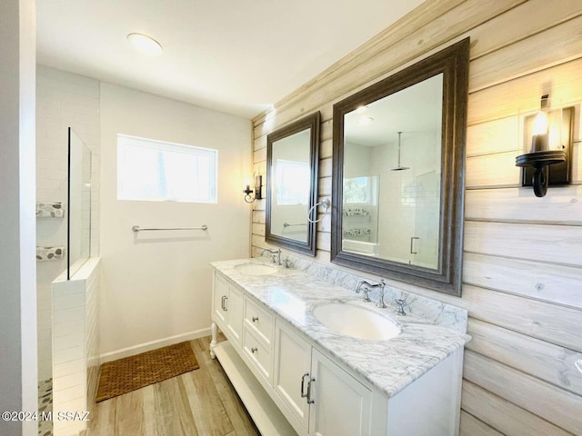 bathroom with vanity, a tile shower, and hardwood / wood-style floors