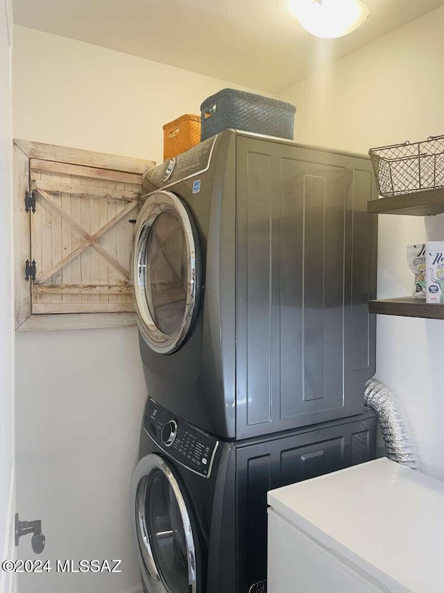 clothes washing area featuring stacked washer and dryer