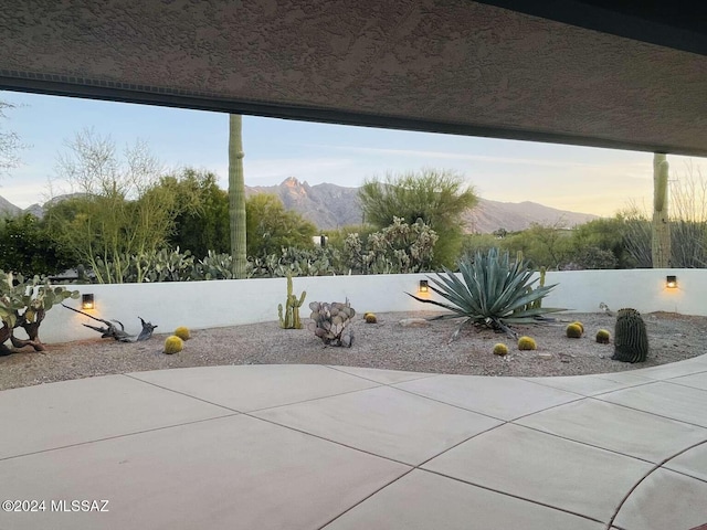 patio terrace at dusk featuring a mountain view