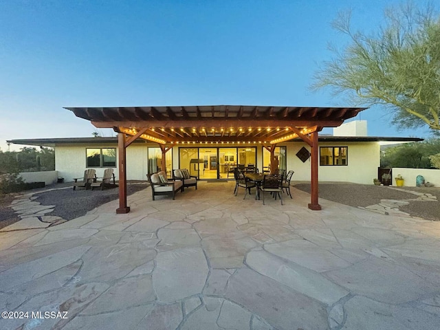 patio terrace at dusk with a pergola and an outdoor hangout area