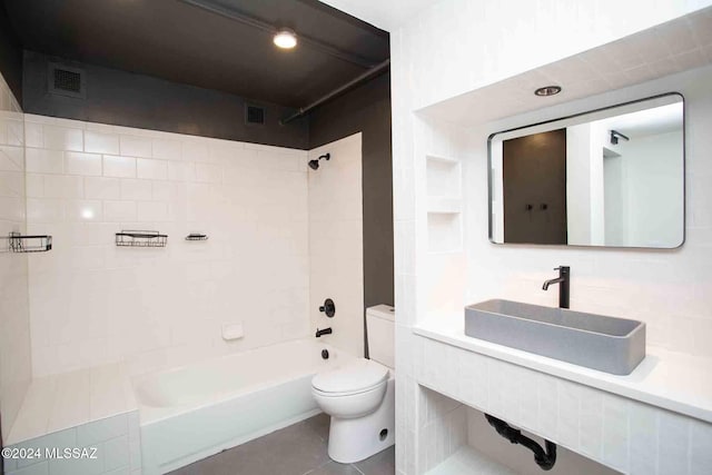 full bathroom with tile patterned floors, toilet, backsplash, sink, and tiled shower / bath combo